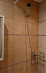 a shower with a shower head in a bathroom at Cozy 2-Bedroom flat with Terrace & Parking by Alfa in Rīga