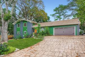a green house with a garage in a yard at Elegant Large 5 bedroom Family Home in Clarkston
