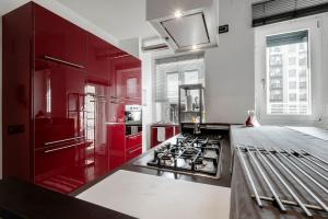 una cucina con armadi rossi e piano cottura di Quite and Bright Tortona District a Milano