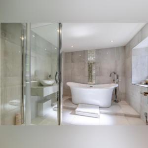 a white bathroom with a tub and a sink at Peak District Period Property near Chatsworth House in Bakewell