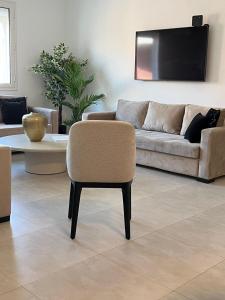a living room with a couch and a chair at NYC trifft auf Top Moderne Wohnung in Hergla in Harqalah +12 photos