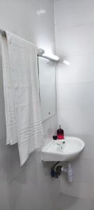 a white bathroom with a sink and a mirror at Boho Comfort Homes in Diani Beach