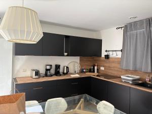 eine Küche mit schwarzen Schränken und viel Licht in der Unterkunft Alpes Ski SUPERDEVOLUY in Le Dévoluy
