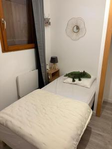 ein Zimmer mit zwei Betten und einem Dinosaurier auf einem Kissen in der Unterkunft Alpes Ski SUPERDEVOLUY in Le Dévoluy + 2 Fotos