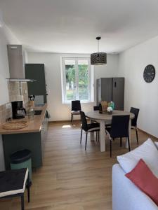 a living room with a table and a kitchen at Maison entièrement rénovée in Dinard