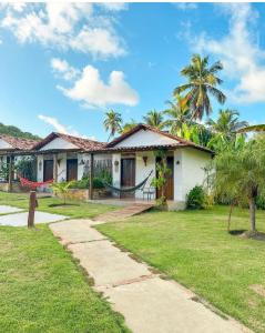 une maison avec un hamac en face de celle-ci dans l'établissement Pousada Villa Morena, à Porto de Pedras 12 autres photos