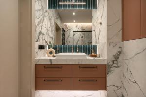 a bathroom with a sink and a mirror at Electra Apartments in Krakow