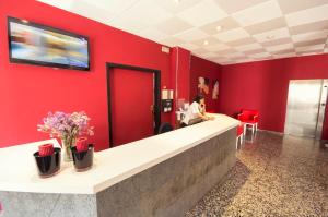 ein Wartezimmer mit einer roten Wand in der Unterkunft azuLine Hotel Llevant in Sant Antoni de Portmany