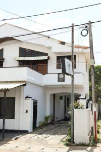 Un edificio blanco con un cartel delante. en Landy Beachscape Hotel & Restaurant, en Negombo