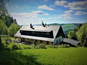 a large barn with a metal roof on a green field at Penzion Na Začátku in Benecko +21 photos