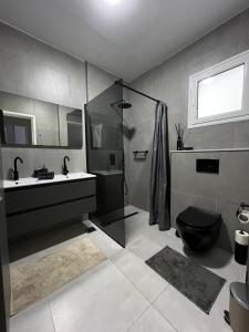 a bathroom with a shower and a toilet and a sink at NYC trifft auf Top Moderne Wohnung in Hergla in Harqalah