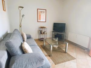 un soggiorno con divano blu e tavolo in vetro di Residenz Strandkrone 09 a Kühlungsborn