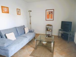 un soggiorno con un divano blu e una TV di Residenz Strandkrone 09 a Kühlungsborn Altre 5 foto