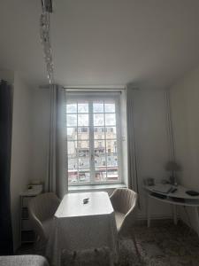 a room with a table and chairs and a window at Studio Le Mansart au pied du Château Insead in Fontainebleau