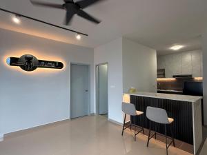 a kitchen with a bar with two chairs and a ceiling fan at Malacca Town TrendCove Homestay in Melaka