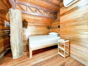 a small room with a bed in a wooden cabin at Tropical Wood 2 chambres proche mer in Koh Samui