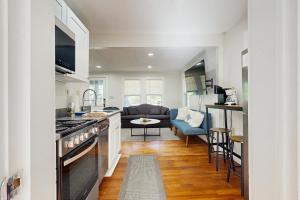 a kitchen with a stove and a living room at White Mountain Dream House in Conway