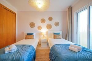 a bedroom with two beds and a chandelier at Surf Spot by Moje Holiday in Portimão