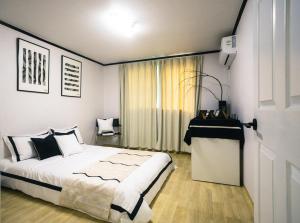 a bedroom with a large bed and a window at Zen House Suwon Hwaseong in Suwon