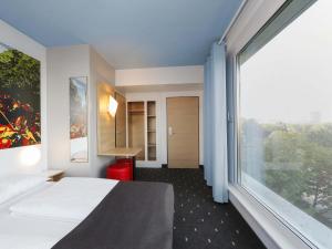 a hotel room with a bed and a large window at B&B Hotel Berlin-Tiergarten in Berlin