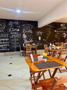 a restaurant with a chalkboard wall with tables and chairs at Pousada Casa Rosada Ilhabela in Ilhabela