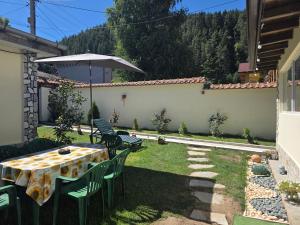 a table and chairs with an umbrella in a yard at Guest House Freya in Beli Iskar