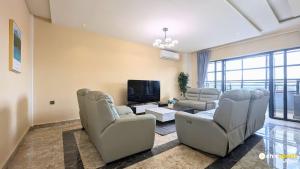 a living room with couches and a flat screen tv at Chic studio with parking and rooftop in Yaoundé
