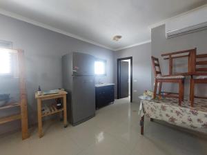 a kitchen with a refrigerator and a table and a chair at Centre studio 16 in Netanya