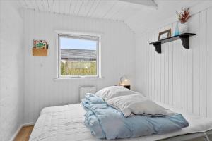 a white bedroom with a bed and a window at 40526-Juelsminde-Pot-Strandby-53 in Sønderby