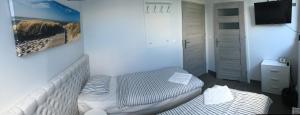 グディニャにあるPanorama Gdynia Roomsのベッド1台とテレビが備わる小さな客室です。