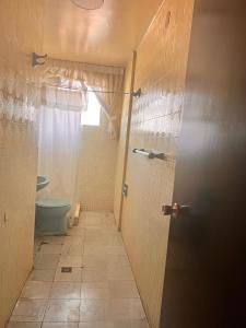 une salle de bain avec toilettes et une porte avec fenêtre dans l'établissement 歇脚休息, à La Playa Bejarano