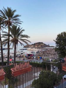 vistas a una playa con palmeras y un puerto en Mythos Home, en Aci Castello