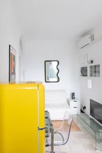 a yellow refrigerator in a room with a bed at Vivace Bilocale con vista sul Naviglio -Mirable PM in Milan