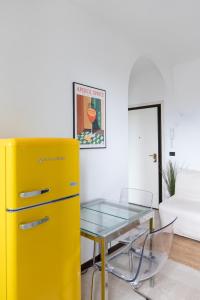 a yellow refrigerator and a glass table in a room at Vivace Bilocale con vista sul Naviglio -Mirable PM in Milan