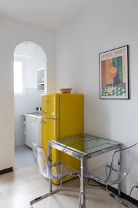 a kitchen with a glass table and a yellow refrigerator at Vivace Bilocale con vista sul Naviglio -Mirable PM in Milan