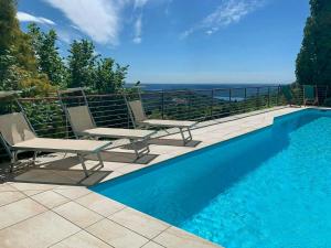 a swimming pool with two chairs and a view of the ocean at Villa With Pool Overlooking Lake Maggiore in Gignese