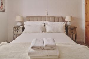 Un dormitorio con una cama blanca con dos toallas encima. en Oakey Cottage - Complimentary Breakfast, en Bourton on the Water