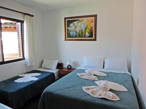 a room with two beds with towels on them at Pousada São Bento in Cunha