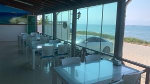 a row of tables and chairs with a car on the beach at Abaş Masmavi Otel in Yumurtalık +17 photos