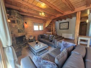 サント・フォア・タロンテーズにあるSplendide chalet 10pers, Sainte Foy Stationのリビングルーム(革張りのソファ、石造りの暖炉付)