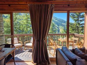 サント・フォア・タロンテーズにあるSplendide chalet 10pers, Sainte Foy Stationのソファと大きな窓のあるリビングルーム