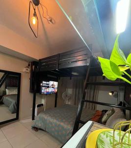 a bedroom with a bunk bed with a tv in it at Tagaytay Staycation with Great Location in Tagaytay