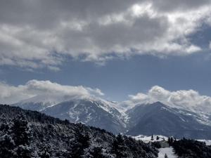 a snow covered mountain range under a cloudy sky at Le lodge étoilé - Station de ski Font-Romeu Pyrénées 2000 in Égat +11 photos