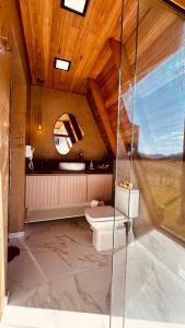 a bathroom with a toilet and a glass shower at Glamping Cabana Aysú in Córrego do Bom Jesus +44 photos