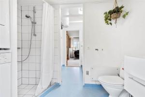 ein weißes Badezimmer mit Toilette und Dusche in der Unterkunft 30016 Beder - Solsortevænget 19 in Beder + 20 Fotos