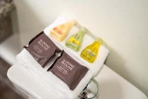 three complimentary soap andodorizers sitting on top of a sink at Hotel Los Andes in San Pedro Sula