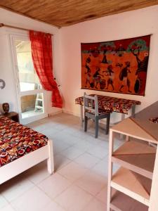 a room with two beds and a table at Chambre d'hôte Maryvonne & Mamadou in Nianing