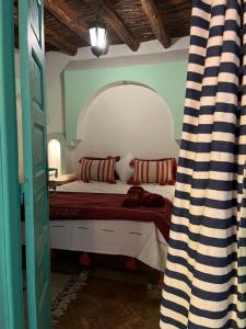 a bedroom with a bed with a large mirror at Riad Hmam Sofa in Taroudant