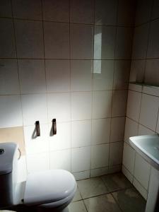 a bathroom with a toilet and a sink at Chambre d'hôte Maryvonne & Mamadou in Nianing