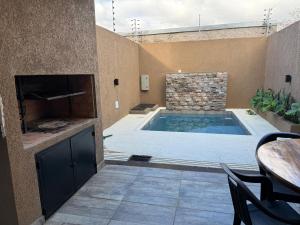 einen Pool in einem Zimmer mit einem Tisch und Stühlen in der Unterkunft Exclusive Dúplex Iguazú in Puerto Iguazú + 26 Fotos